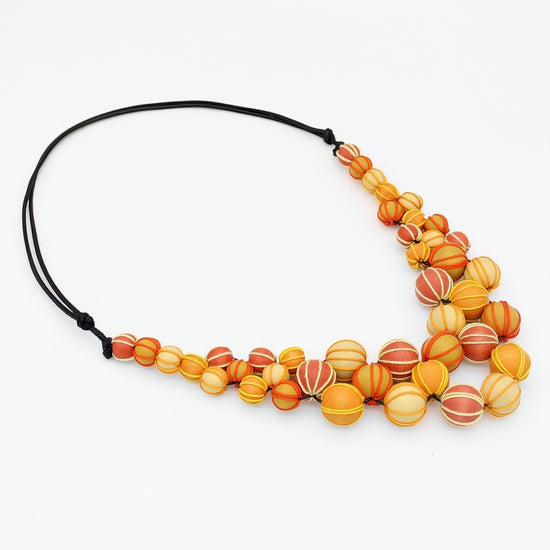 Necklace with orange and yellow beaded design on a white background