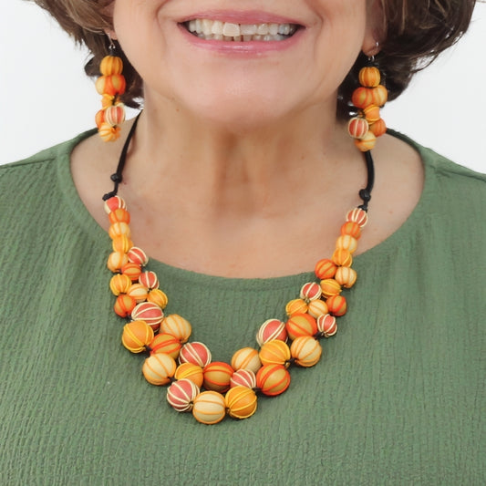 Woman wearing a colorful beaded necklace and earrings on a white background