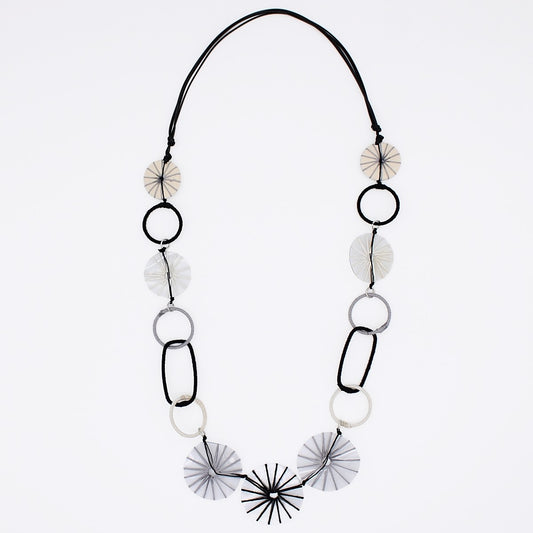 Necklace with black and white circular and fan-shaped beads on a light gray background