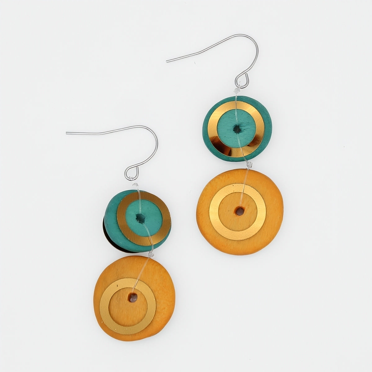 Pair of earrings with circular designs in green, gold, and orange on a white background
