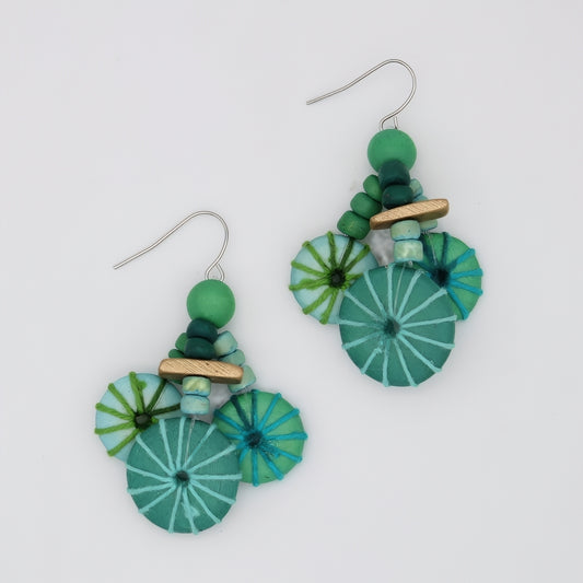 Pair of green and blue earrings on a white background