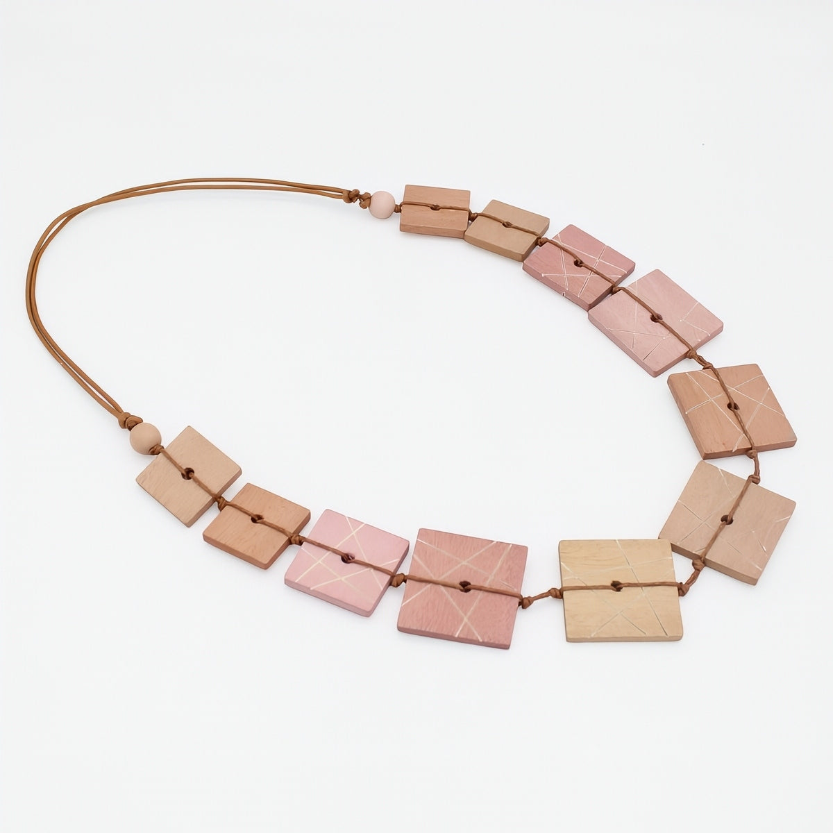 Necklace with square pink and beige beads on a white background