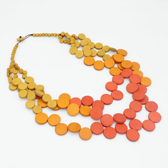 Necklace with orange and red disc beads on a white background