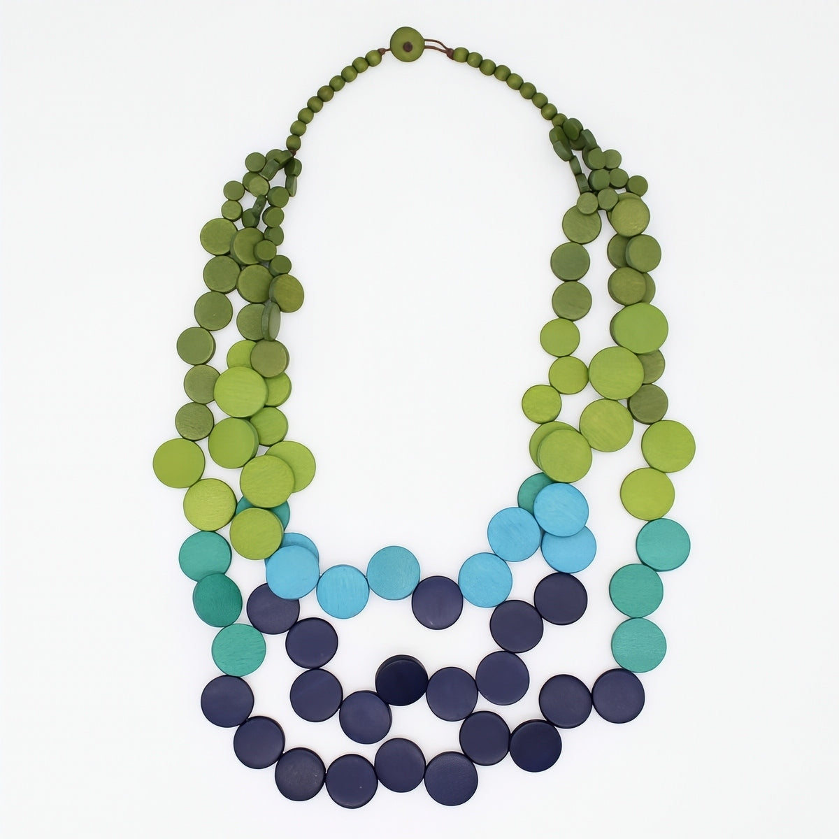 A multi-strand beaded necklace made of flat circular discs, featuring a color gradient from olive and lime green at the top, through light blue, teal, and dark navy at the bottom, displayed on a clean white background.