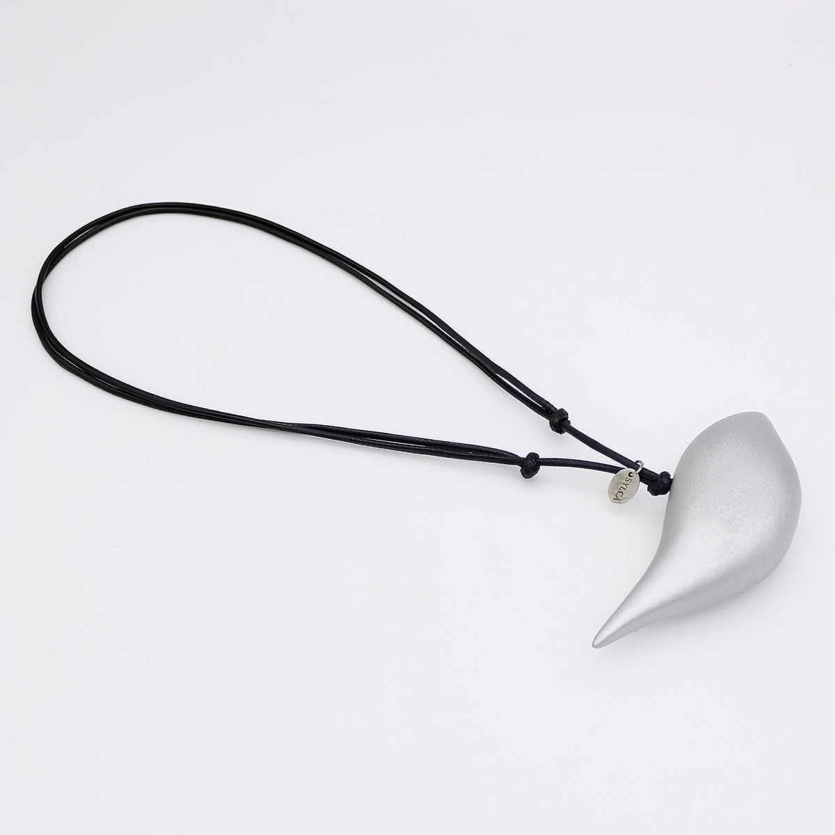 Silver pendant on a black cord against a white background