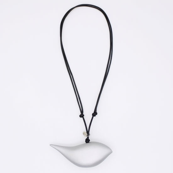 silver bird pendant on a black cord against a white background