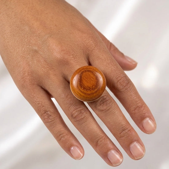 Wooden ring on a hand against a white background