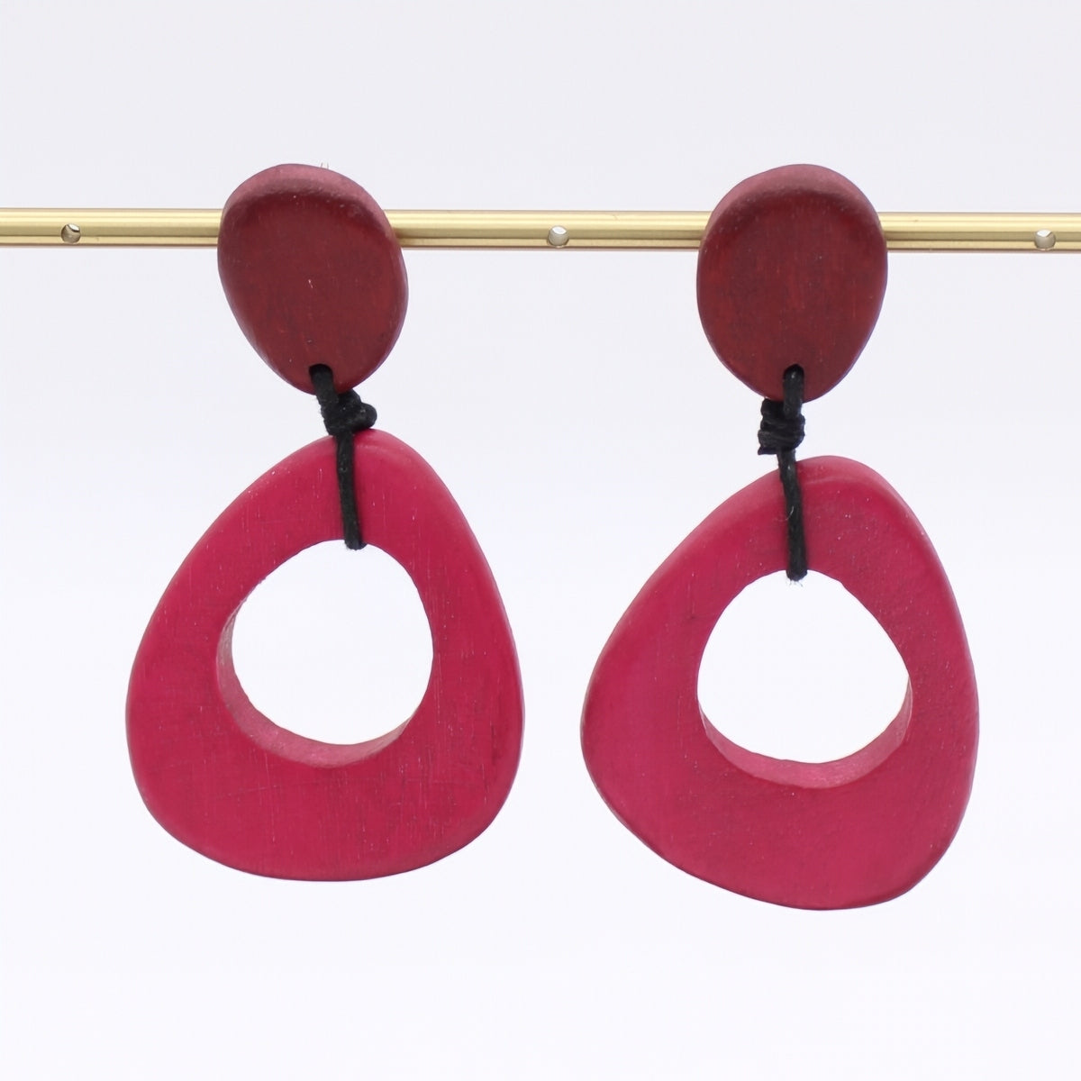 Pair of pink earrings with red tops on a white background