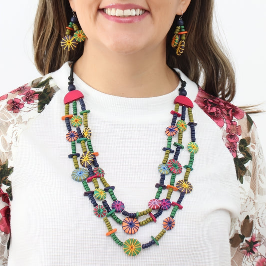 Woman wearing a colorful beaded necklace and earrings on a white background
