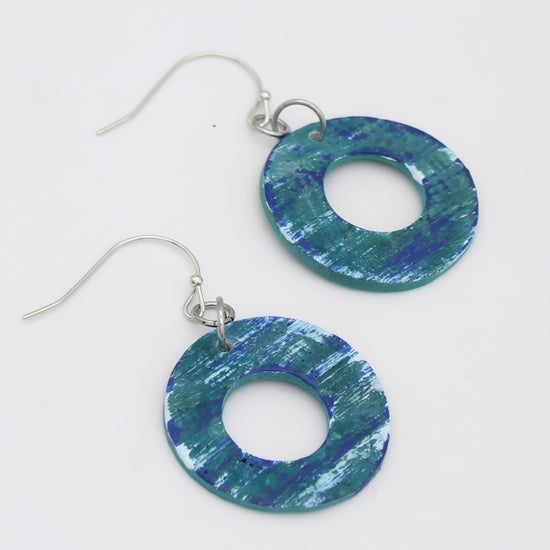 Blue and green circular earrings on a white background