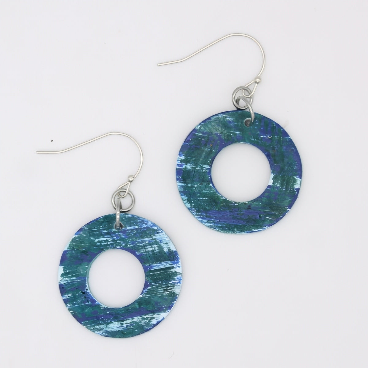 Pair of blue and green circular earrings on a white background