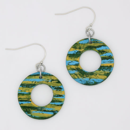 Pair of earrings with green and blue abstract design on a white background
