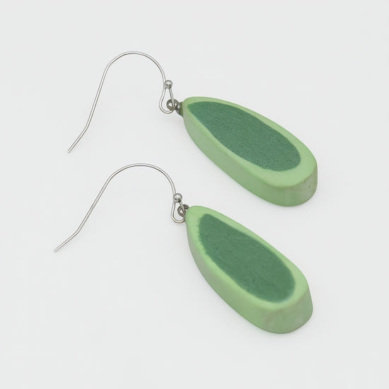 Green teardrop-shaped earrings on a white background