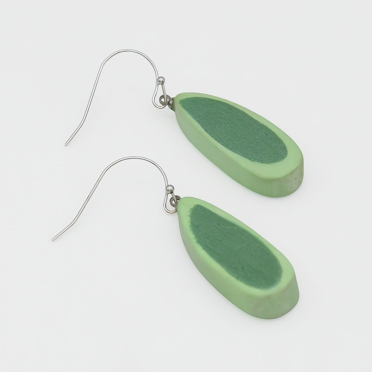 Green teardrop-shaped earrings on a white background
