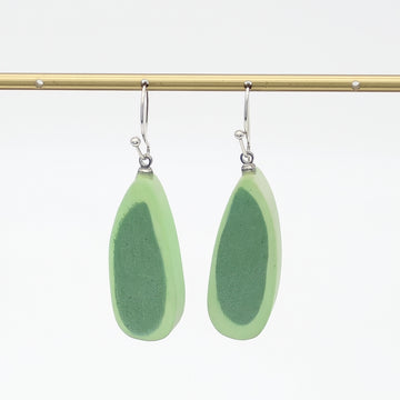 Pair of green teardrop earrings on a gold rod against a white background