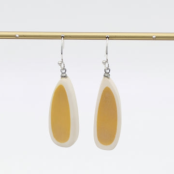 Pair of earrings with yellow and white teardrop design on a white background