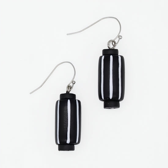 A pair of black and white striped glass drop earrings with silver-tone fishhook wires, shown on a plain white background.