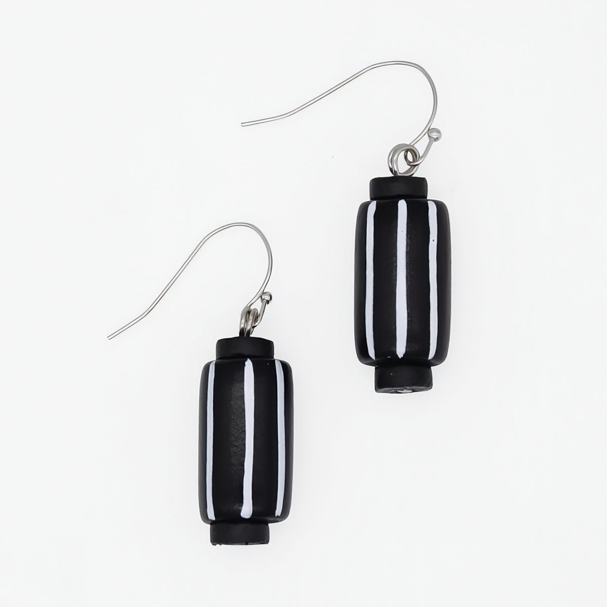 A pair of black and white striped glass drop earrings with silver-tone fishhook wires, shown on a plain white background.