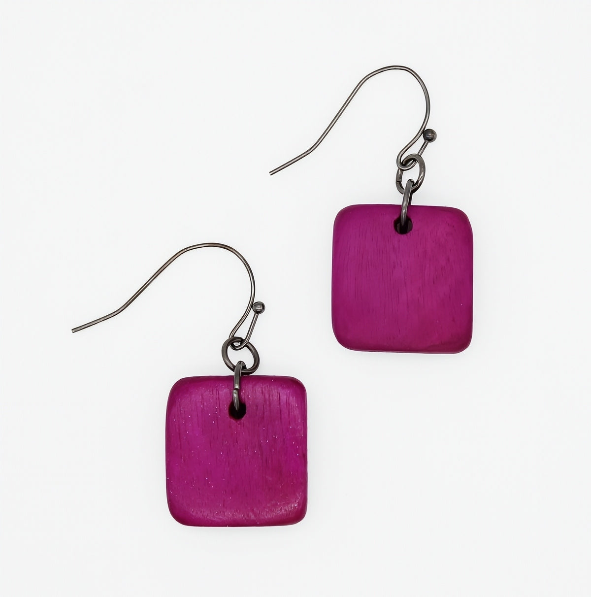 A pair of square-shaped drop earrings with a textured magenta-purple wooden disc and a dark metal fishhook ear wire, shown on a plain white background.