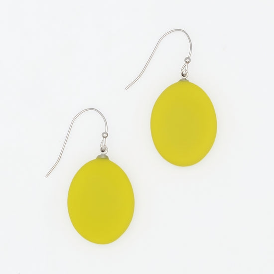 A pair of yellow oval drop earrings with silver fishhook wires, displayed on a clean white background.