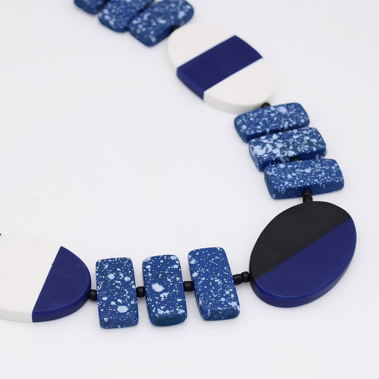 Necklace with blue and white speckled beads on a white background