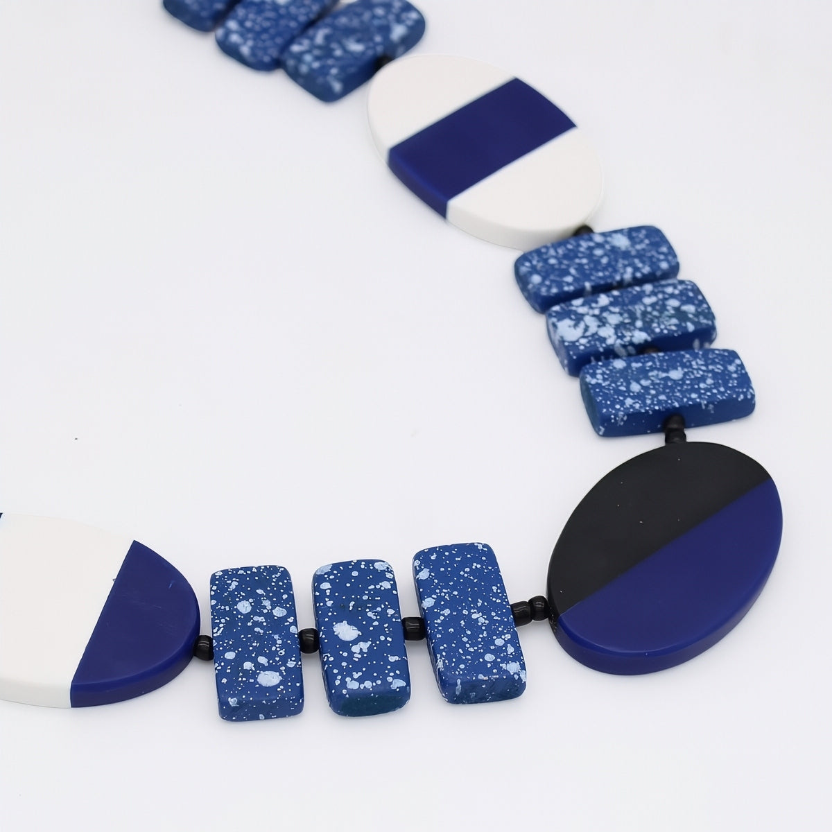 Necklace with blue and white speckled beads on a white background