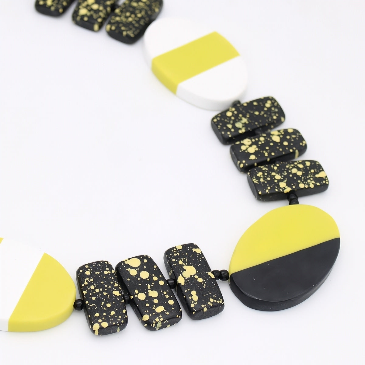 Necklace with black and yellow speckled beads on a white background