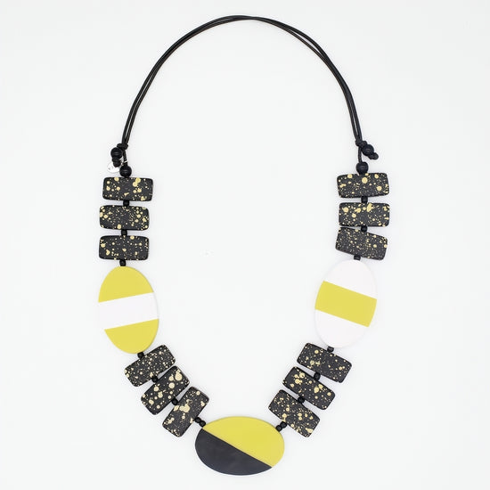 Necklace with geometric black, yellow, and white beads on a white background