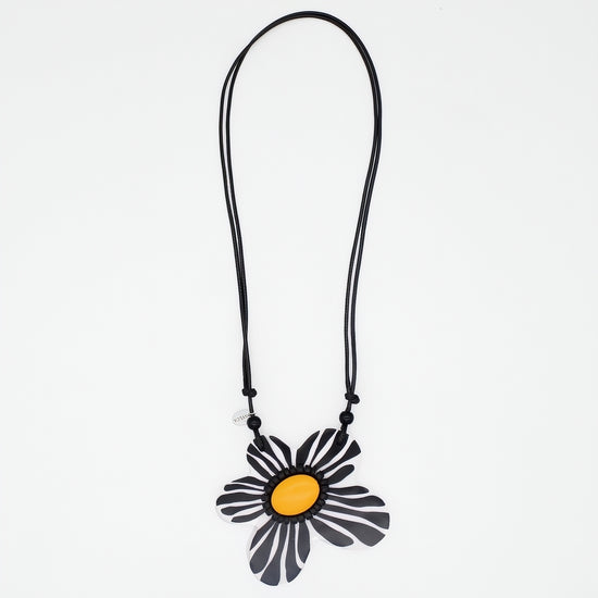 Necklace with a black and yellow flower pendant on a white background