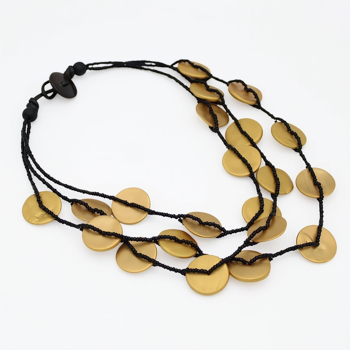 A multi-strand black cord necklace featuring flat, circular gold-toned disc pendants, displayed on a clean white background.