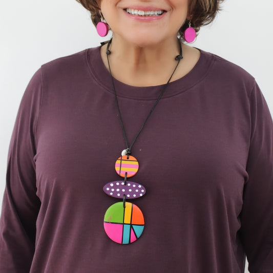 Person wearing a colorful necklace with a plain background