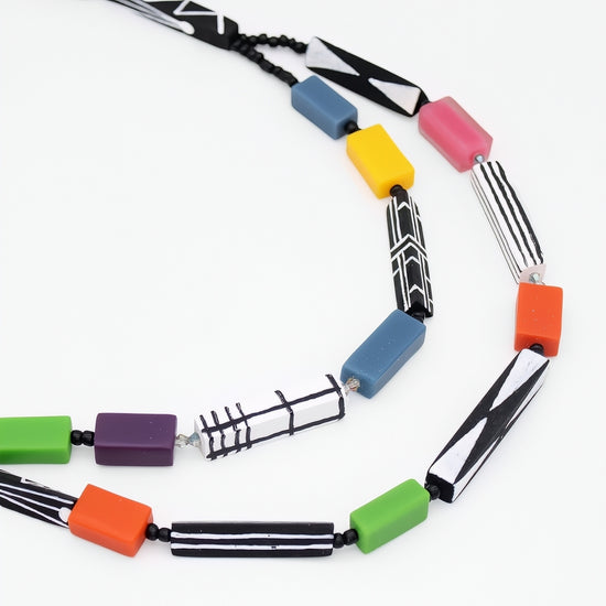 Colorful necklace with geometrically shaped beads on a white background