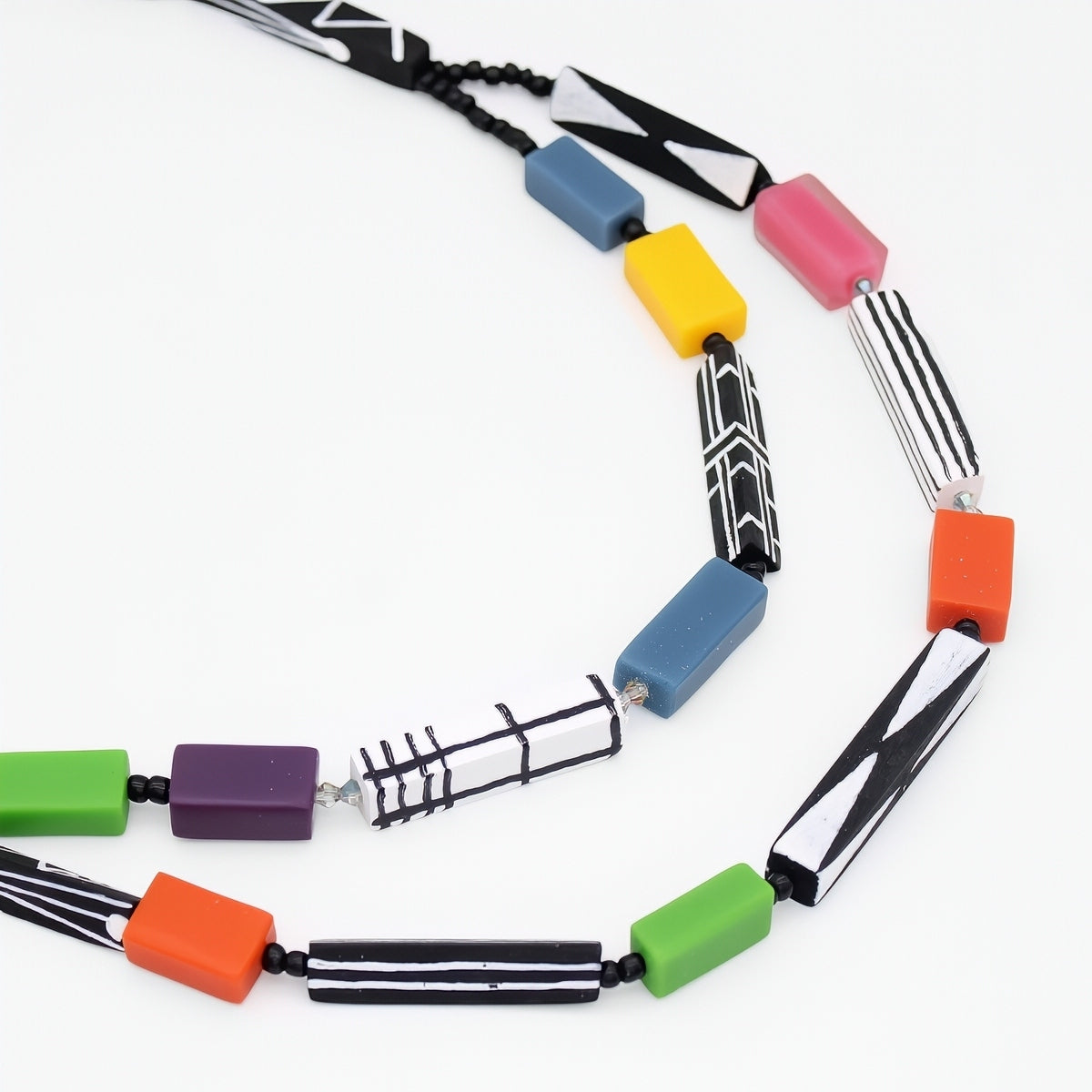 Colorful necklace with geometrically shaped beads on a white background