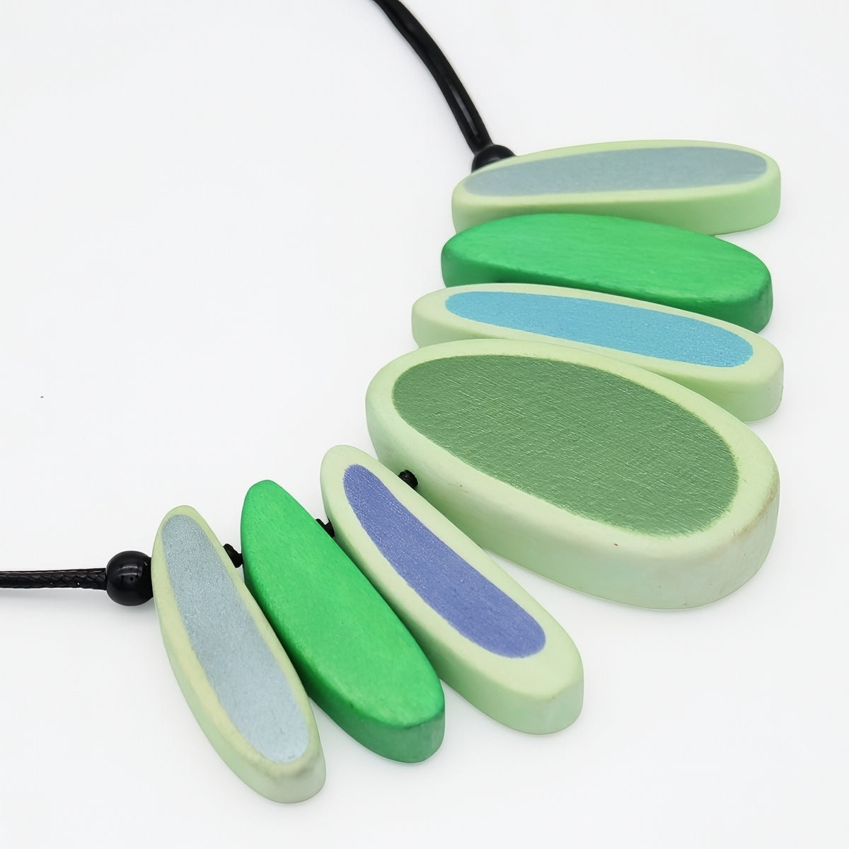 Necklace with green and blue oval beads on a white background