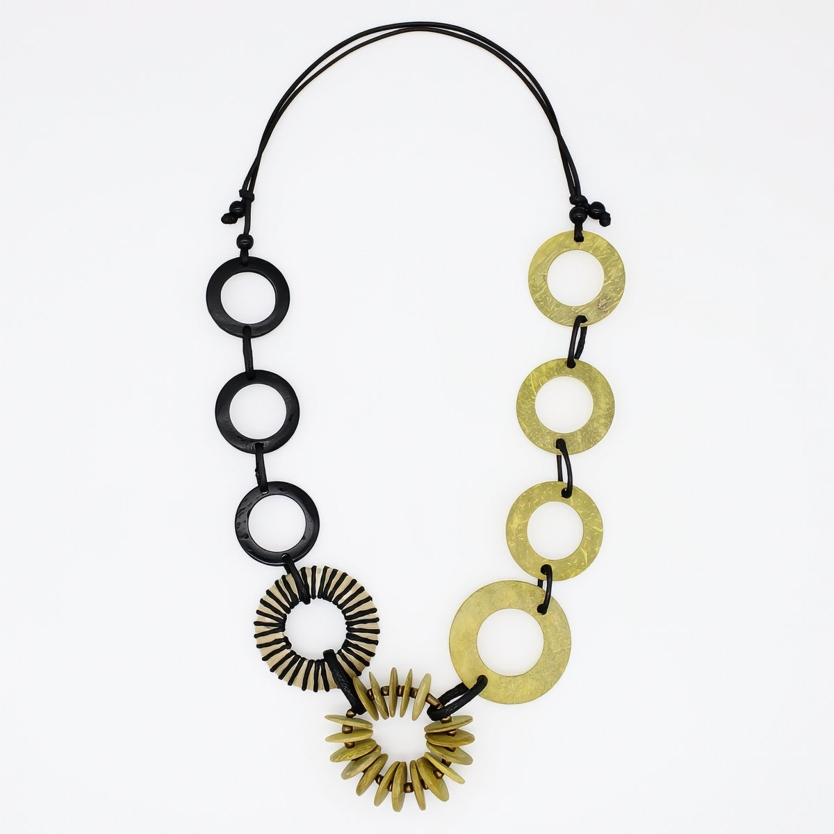 A modern statement necklace featuring alternating matte black circular discs and textured gold-tone disc and sunburst elements, suspended on a black cord against a plain white background.
