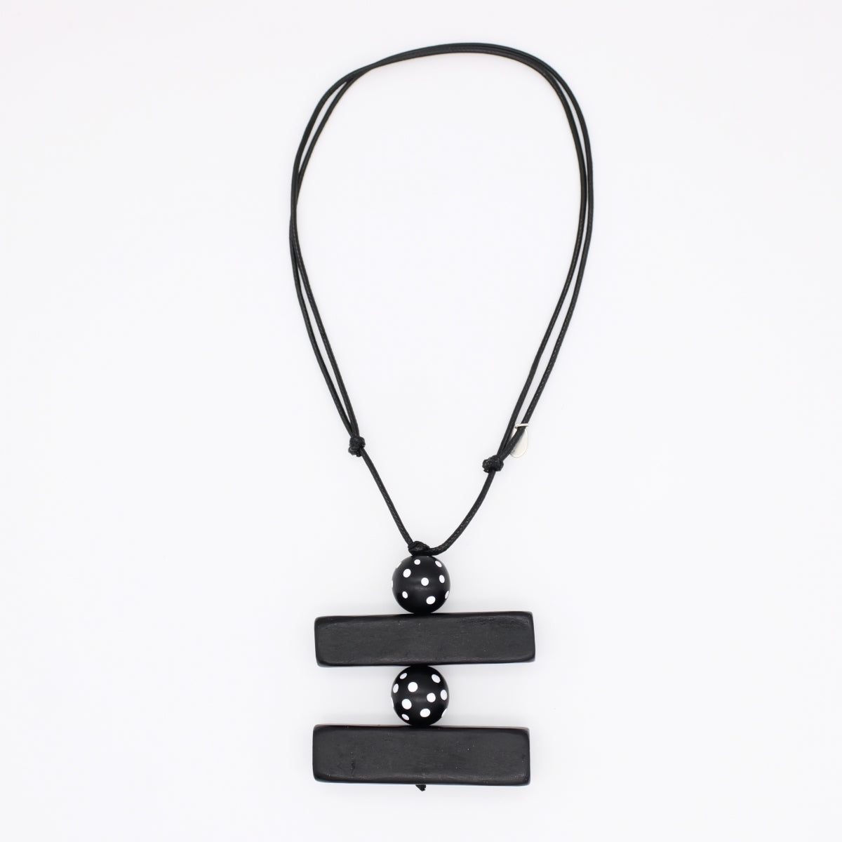 A black geometric pendant necklace featuring two horizontal rectangular bars connected by a central perforated sphere, suspended on a black cord against a plain white background.
