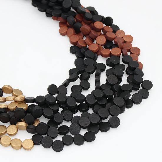 Three strands of small round disc beads in black, reddish brown, and metallic gold, arranged on a plain white background.