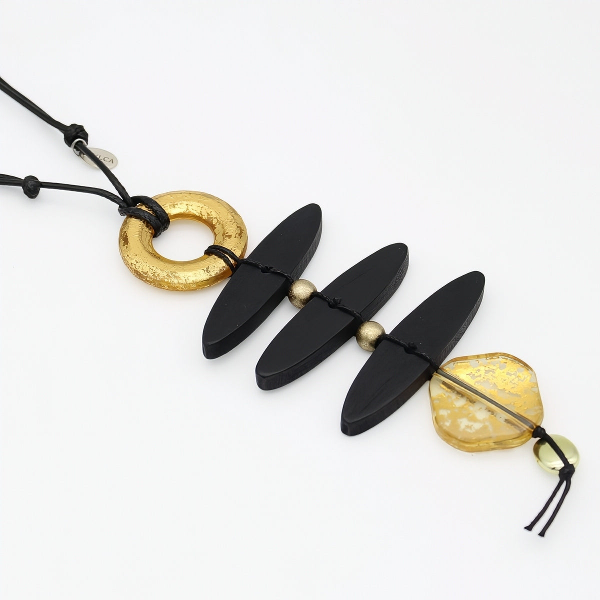 Close up of sculptural black wood necklace and gold resin accents