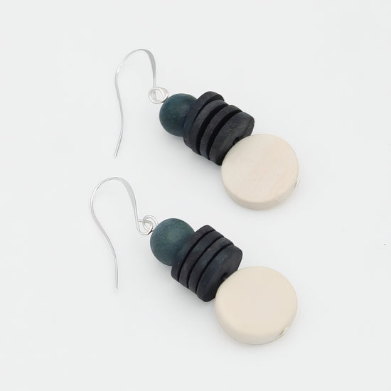 Pair of earrings with black, blue, and white circular beads on a white background