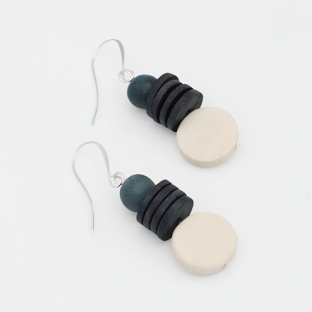 Pair of earrings with black, blue, and white circular beads on a white background