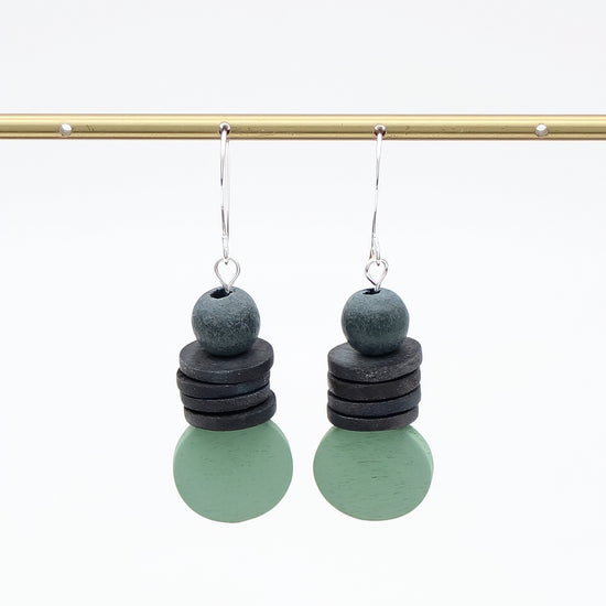 Pair of earrings with stacked circular charms on a white background