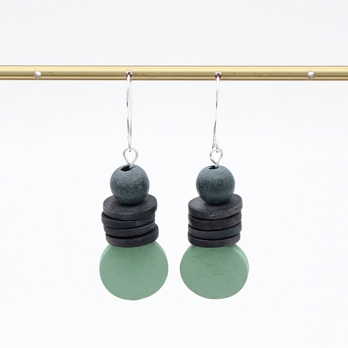 Pair of earrings with stacked circular charms on a white background
