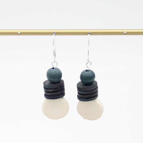 Pair of earrings with layered beads on a white background