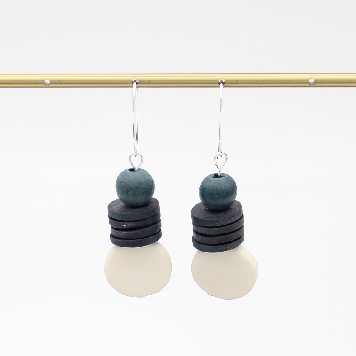 Pair of earrings with layered beads on a white background