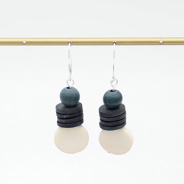Pair of earrings with layered beads on a white background