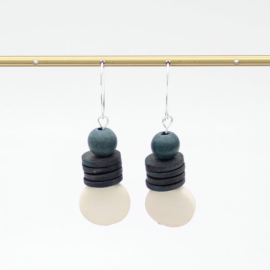 Pair of earrings with layered beads on a white background