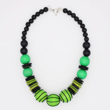 A beaded necklace featuring matte black round beads, vibrant green round beads, and striped lime green and black disc beads, with a silver clasp, shown on a plain white background.