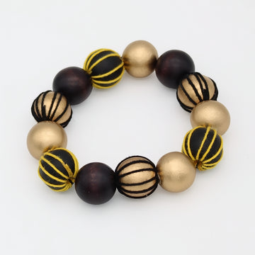 A beaded stretch bracelet featuring alternating matte gold, glossy dark brown, and striped black-and-gold beads, displayed on a clean white background.