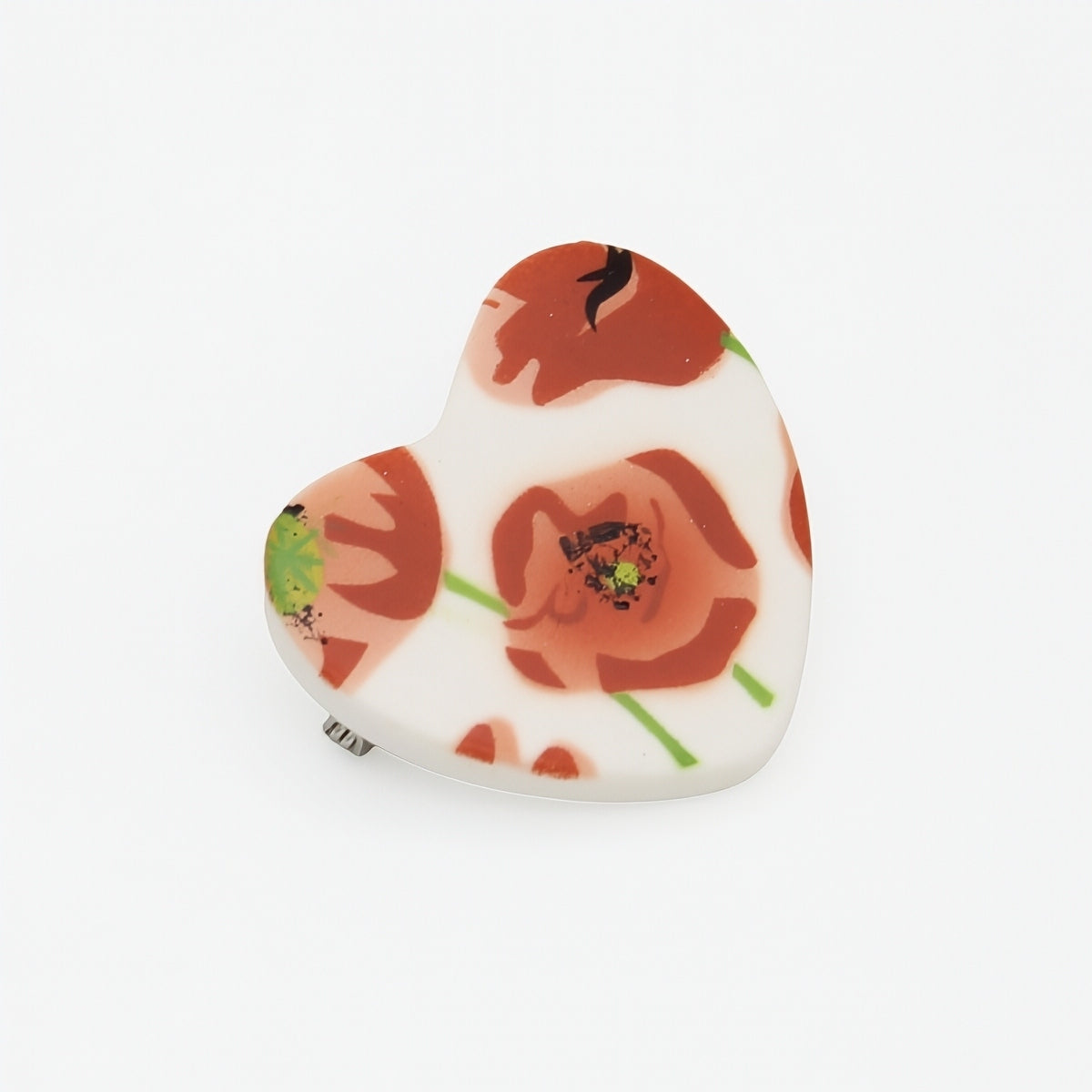 Heart-shaped pin with floral design on a white background