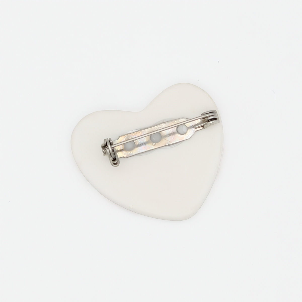 Heart-shaped brooch with a silver bar on a white background